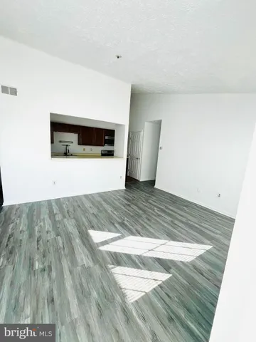 a view of an empty room with wooden floor