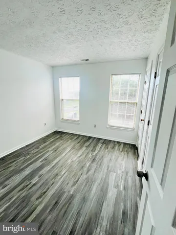 an empty room with wooden floor and window