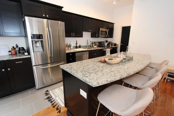 a kitchen with granite countertop stainless steel appliances a refrigerator a stove a sink and a refrigerator