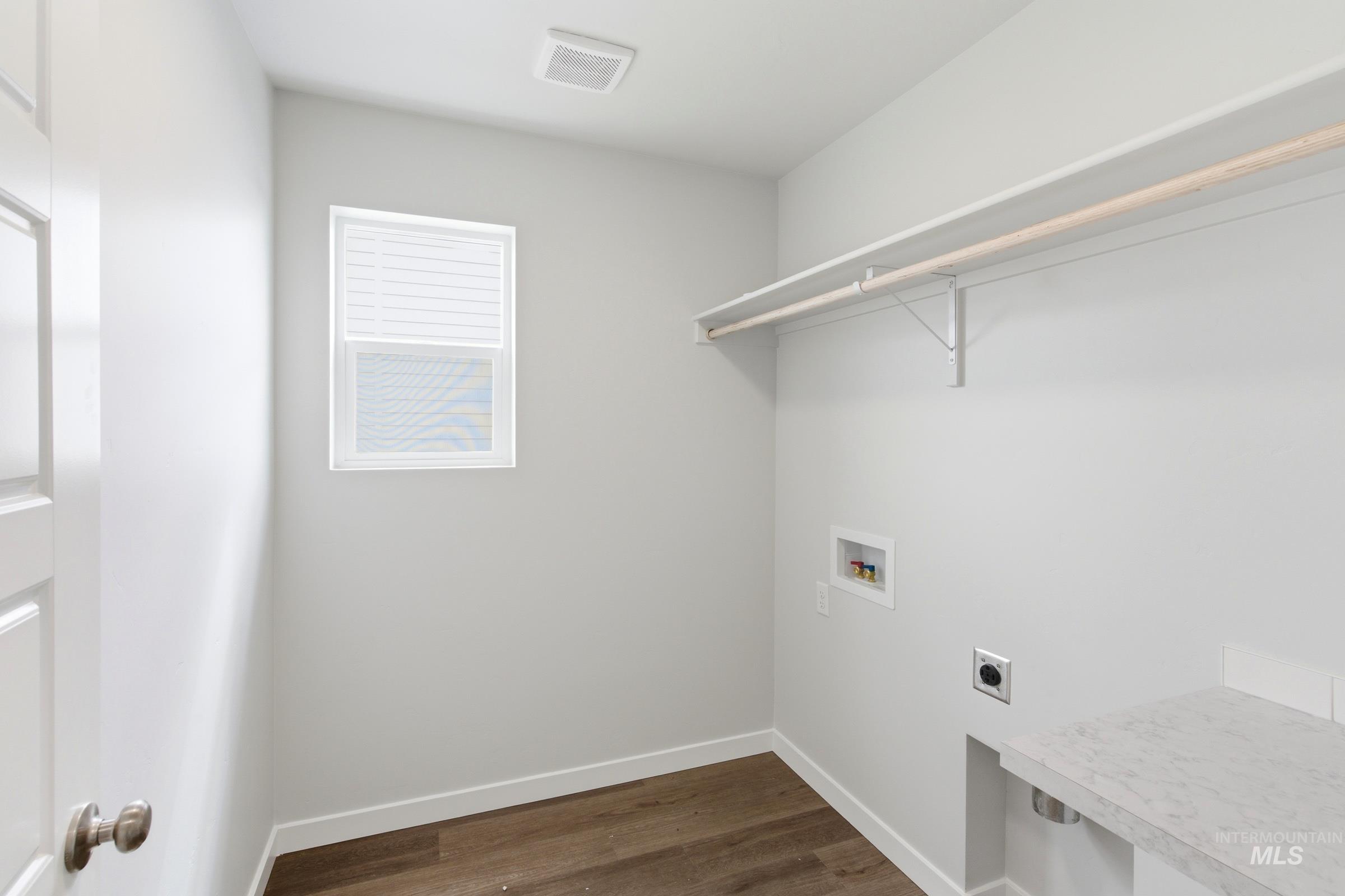 12829 Decatur Street Nampa, ID 83651 - Photo 22 of 33 Functional laundry space featuring wood-finish flooring and a white window with blinds
