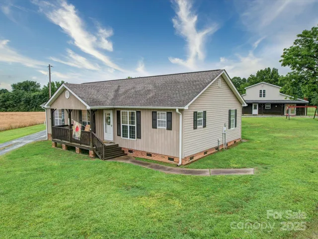 a view of a house with a yard and sitting area
