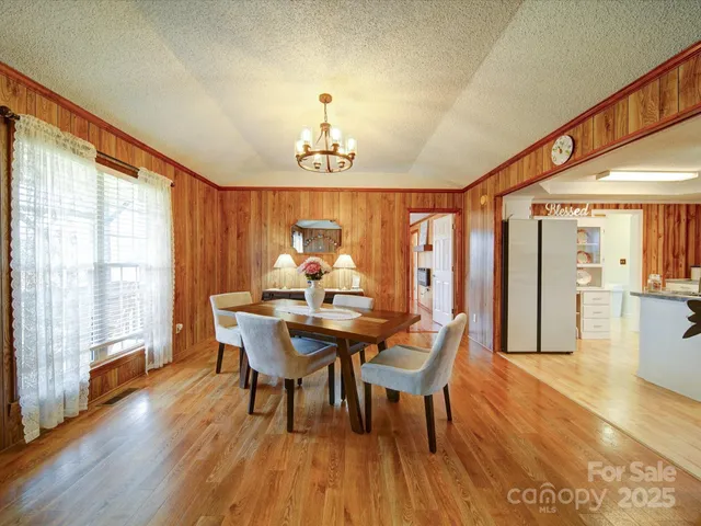 a dining room with furniture a chandelier and wooden floor
