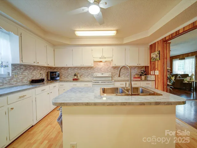 a kitchen with stainless steel appliances granite countertop a sink a stove counter space and cabinets