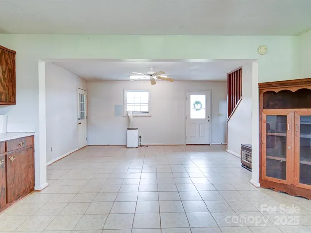 a view of an empty room with window and stairs