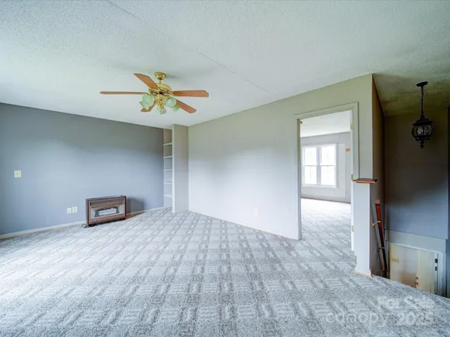 wooden floor in a hall with a window and a ceiling fan