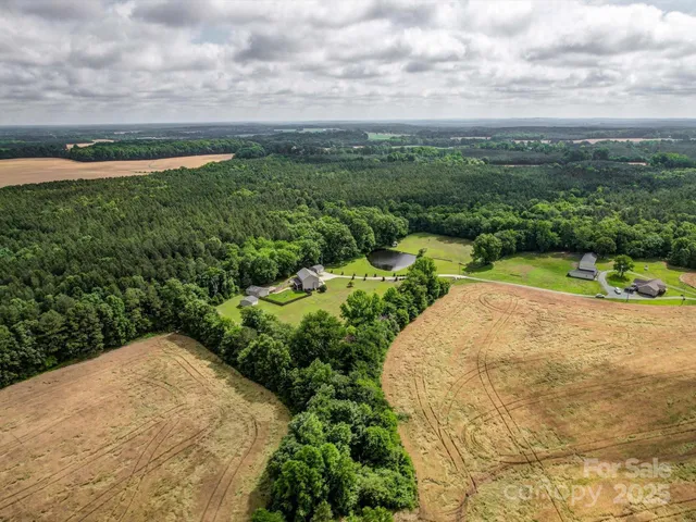 a view of a pathway both side of grassy field with shrub
