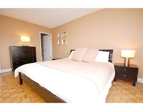 33 Pond Avenue, Unit 524 Brookline, MA 02445 - Photo 11 of 26 a bedroom with a bed and a night stand