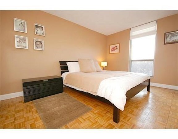 33 Pond Avenue, Unit 524 Brookline, MA 02445 - Photo 12 of 26 a bedroom with a bed and wooden floor