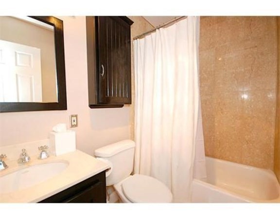 33 Pond Avenue, Unit 524 Brookline, MA 02445 - Photo 13 of 26 a bathroom with a sink a toilet and a mirror