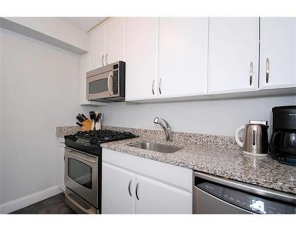 33 Pond Avenue, Unit 524 Brookline, MA 02445 - Photo 9 of 26 a kitchen with granite countertop stainless steel appliances sink stove and cabinets