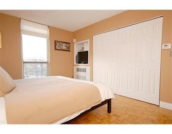 33 Pond Avenue, Unit 524 Brookline, MA 02445 - Photo 10 of 26 a bedroom with a bed table and a flat screen tv