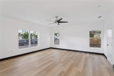 an empty room with wooden floor and windows