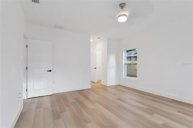 an empty room with a window and wooden floor