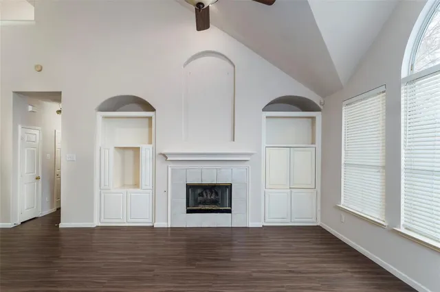 wooden floor fireplace and windows in an empty room