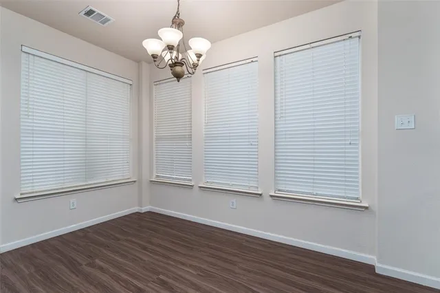 a view of a room with wooden floor and chandelier