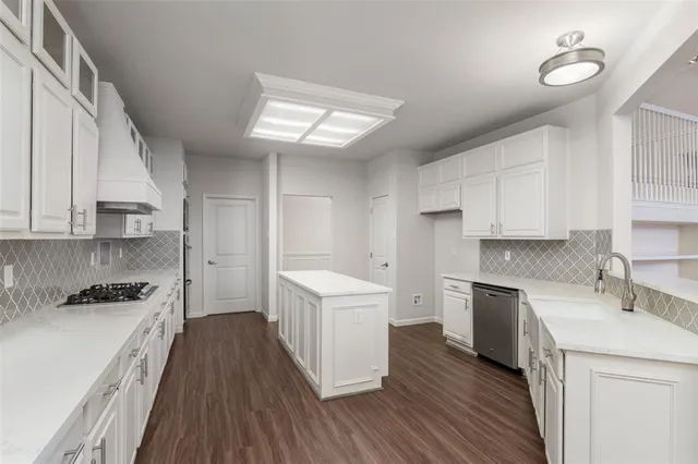 a kitchen with a sink a counter top space stainless steel appliances and cabinets