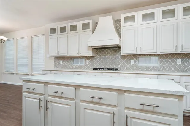 a kitchen with white cabinets and sink