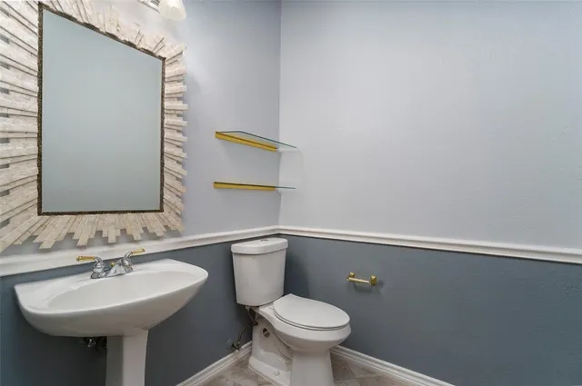 a bathroom with a sink mirror and toilet