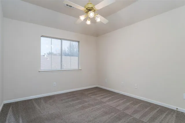 an empty room with a window and a fan