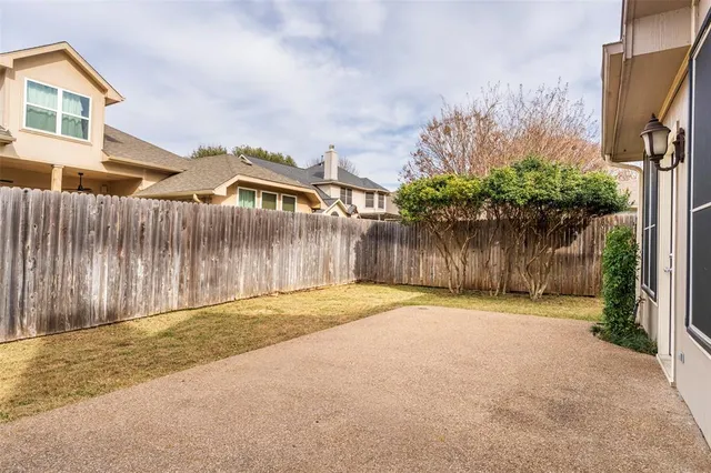 a backyard of a house with lots of green space and wooden fence