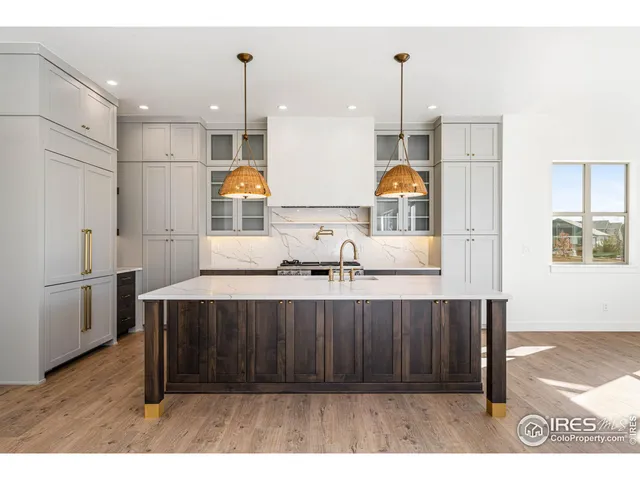 a kitchen with stainless steel appliances a sink cabinets and wooden floor