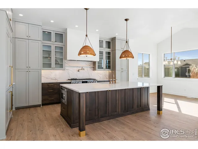 a kitchen with stainless steel appliances granite countertop a sink a stove and a wooden floors