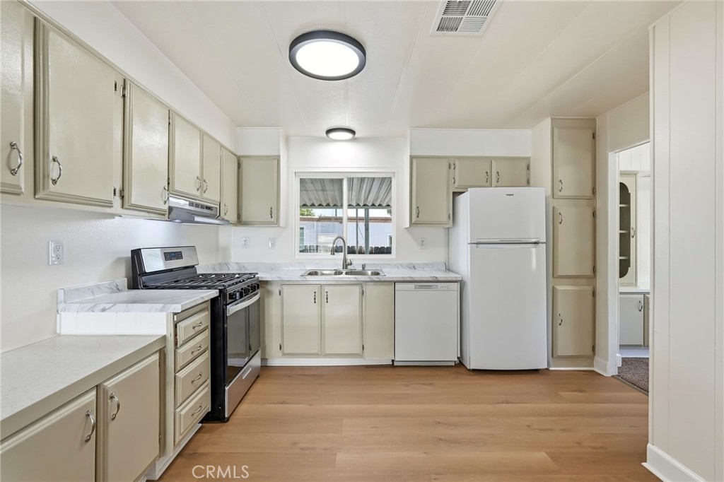 2250 West Mill Street, Unit 104 Colton, CA 92324 - Photo 13 of 28 a kitchen with a sink a refrigerator a stove and cabinets