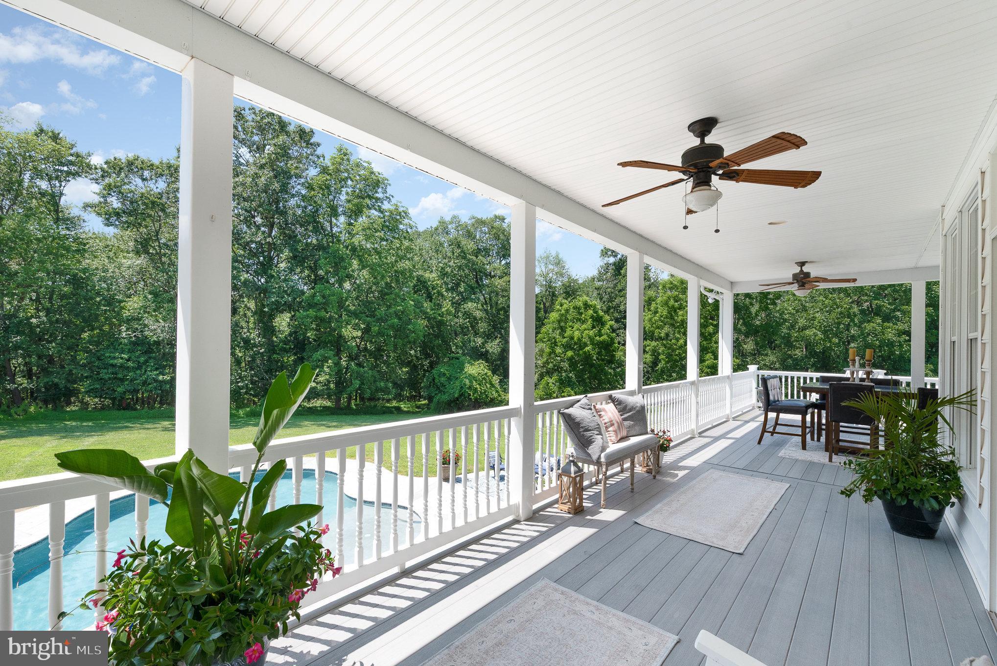 5330 Long Corner Road White Hall, MD 21161 - Photo 30 of 66 a view of a patio with a table chairs and a floor to ceiling window