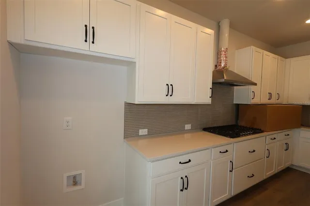 a kitchen with granite countertop white cabinets and white appliances