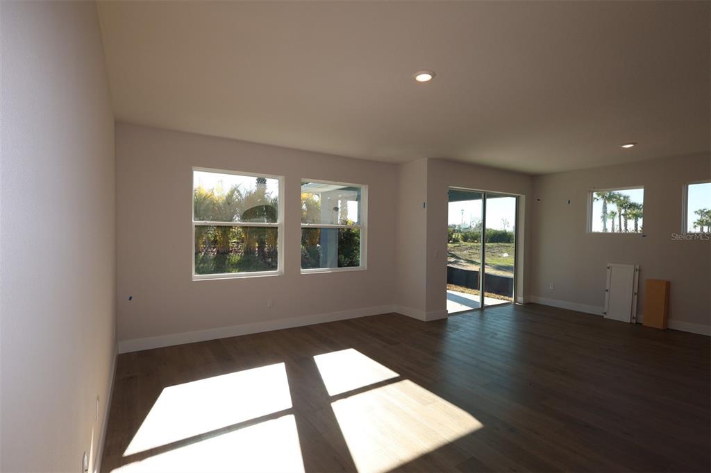 5263 Everlong Drive Apollo Beach, FL 33572 - Photo 7 of 18 a view of an empty room with wooden floor and windows