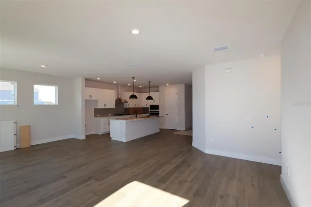 a kitchen with stainless steel appliances a refrigerator and wooden floor