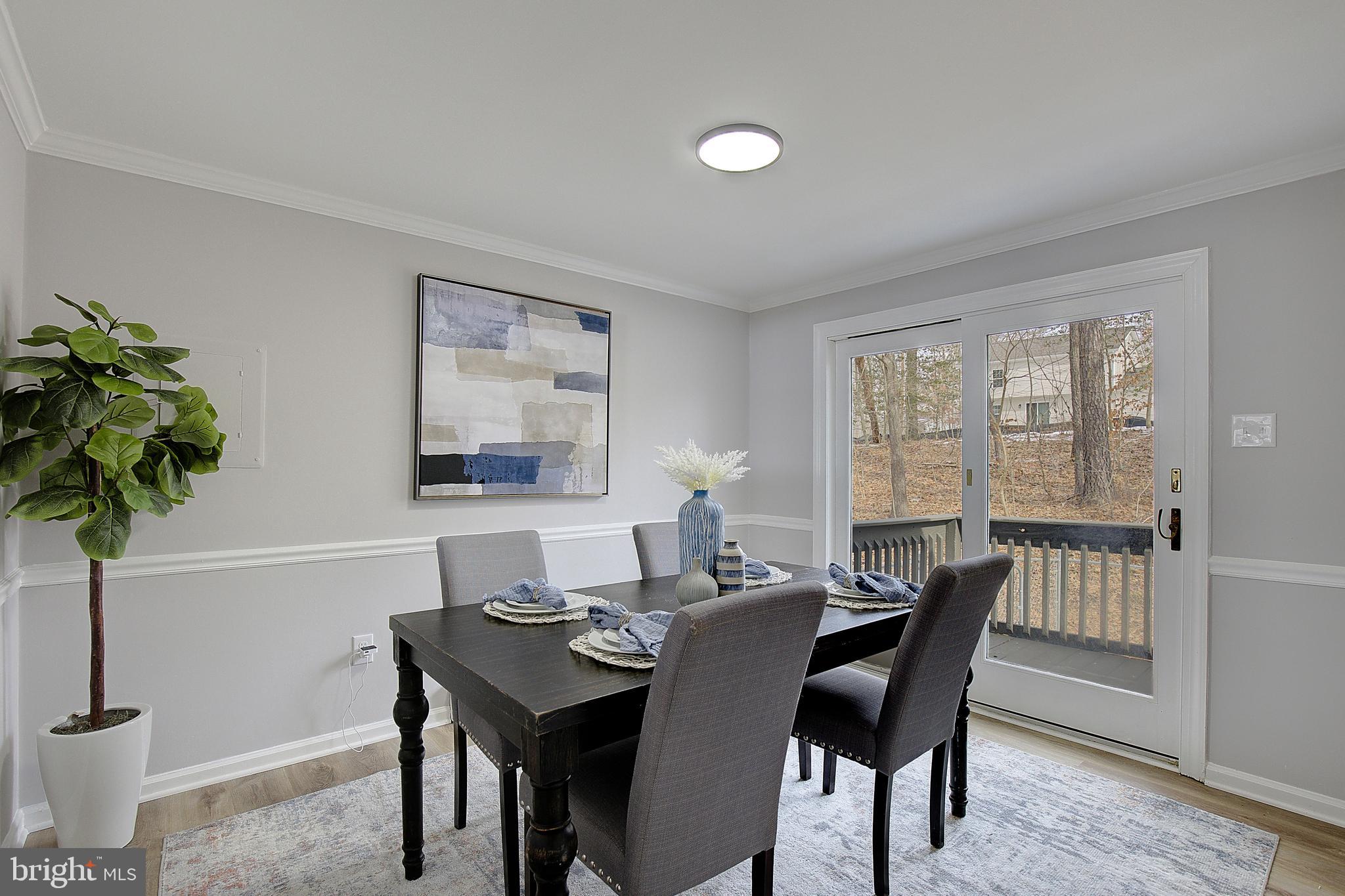 12070 Rousby Hall Road Lusby, MD 20657 - Photo 11 of 36 a view of a dining room with furniture and a potted plant