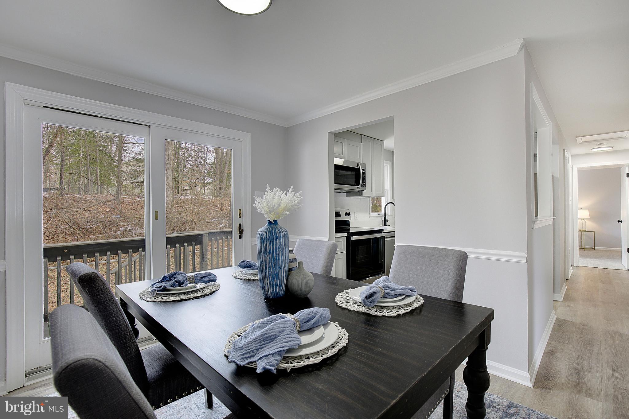 12070 Rousby Hall Road Lusby, MD 20657 - Photo 12 of 36 a view of a dining room with furniture a large window and dining table