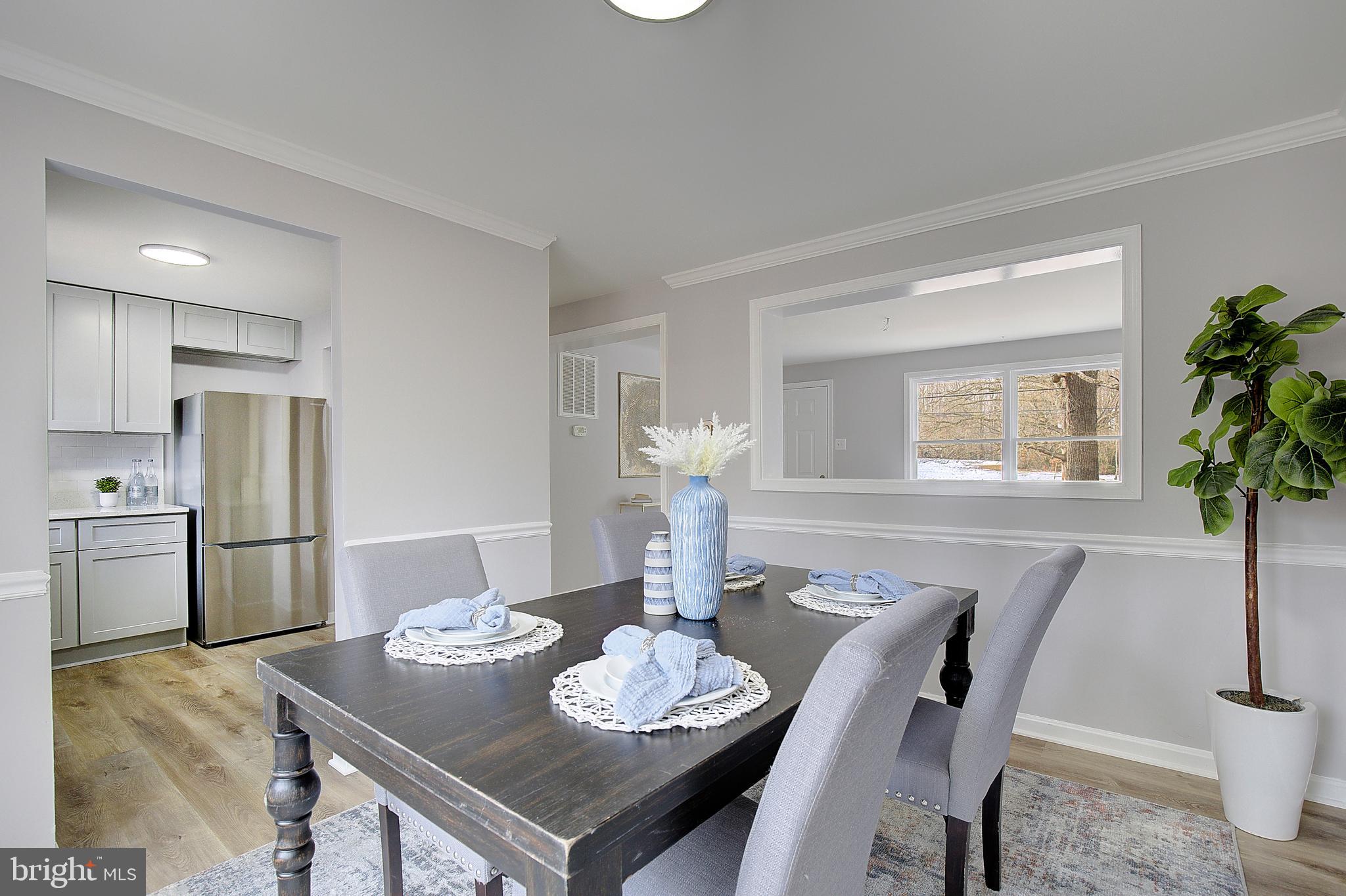 12070 Rousby Hall Road Lusby, MD 20657 - Photo 13 of 36 a view of a dining room with furniture and a potted plant
