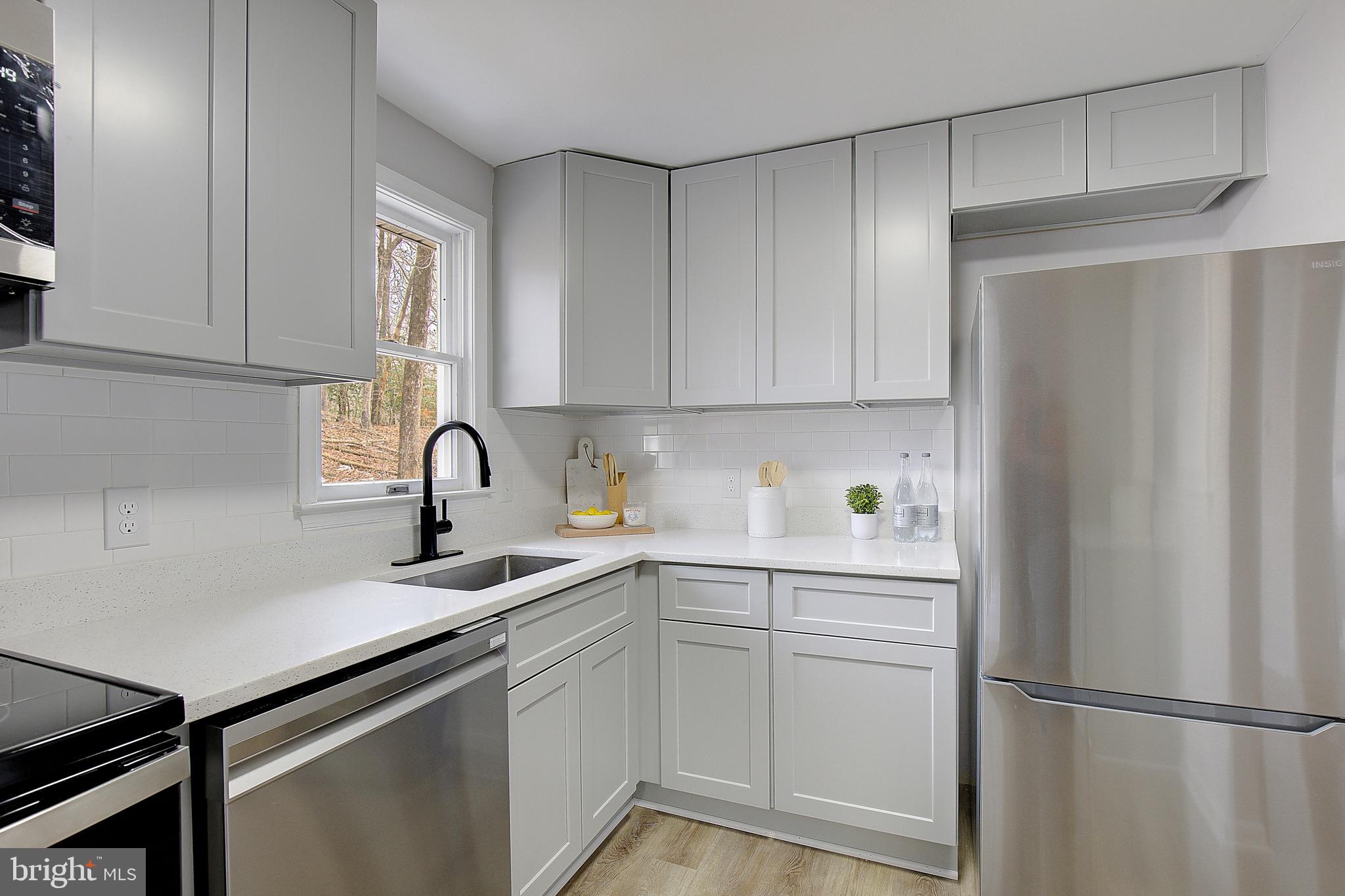 12070 Rousby Hall Road Lusby, MD 20657 - Photo 16 of 36 a kitchen with a sink cabinets and stainless steel appliances
