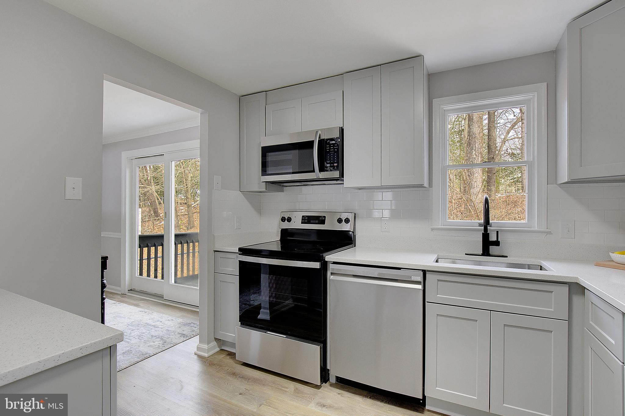 12070 Rousby Hall Road Lusby, MD 20657 - Photo 17 of 36 a kitchen with a sink stove and microwave