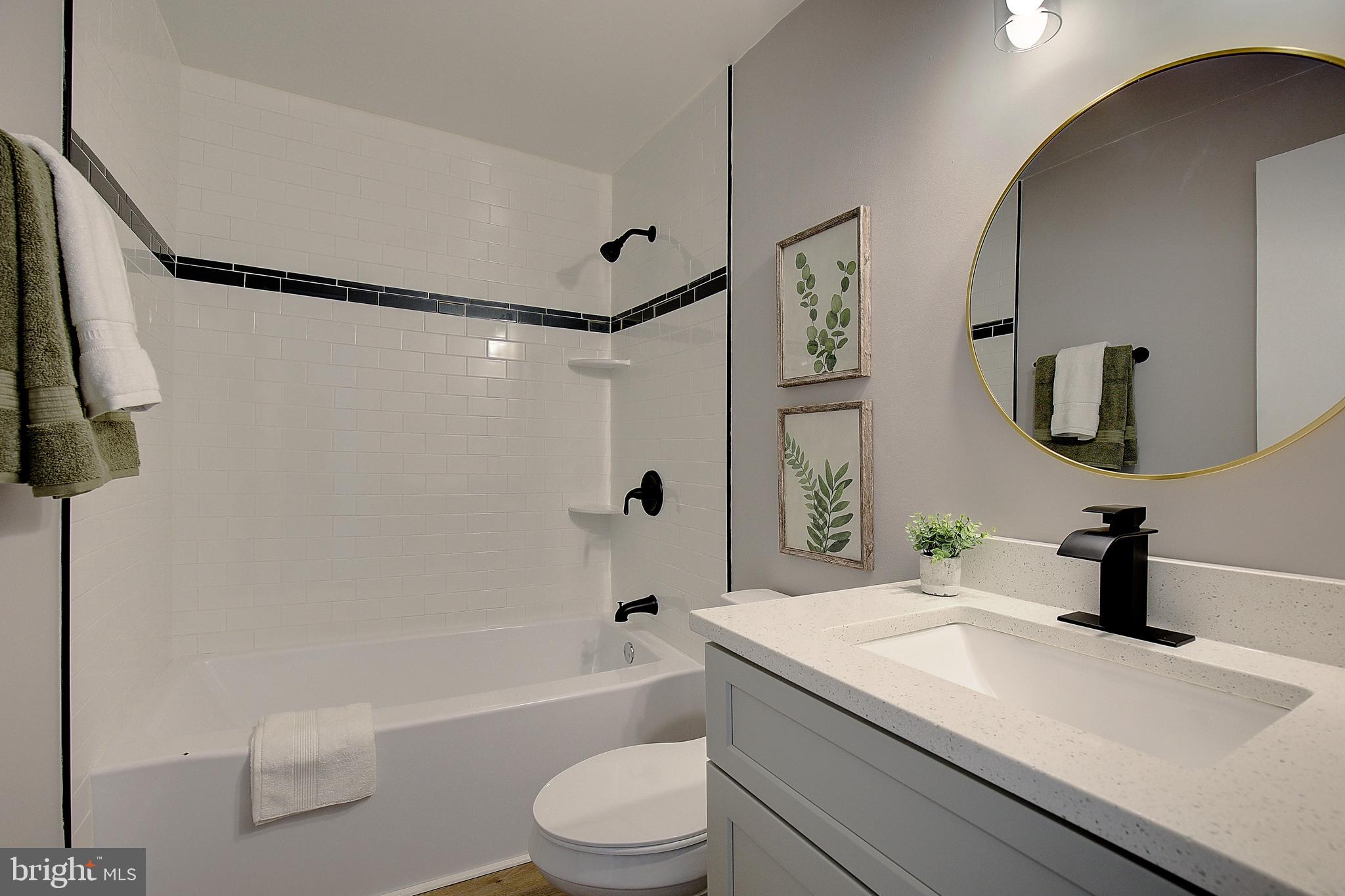 12070 Rousby Hall Road Lusby, MD 20657 - Photo 19 of 36 a bathroom with a granite countertop sink toilet and shower
