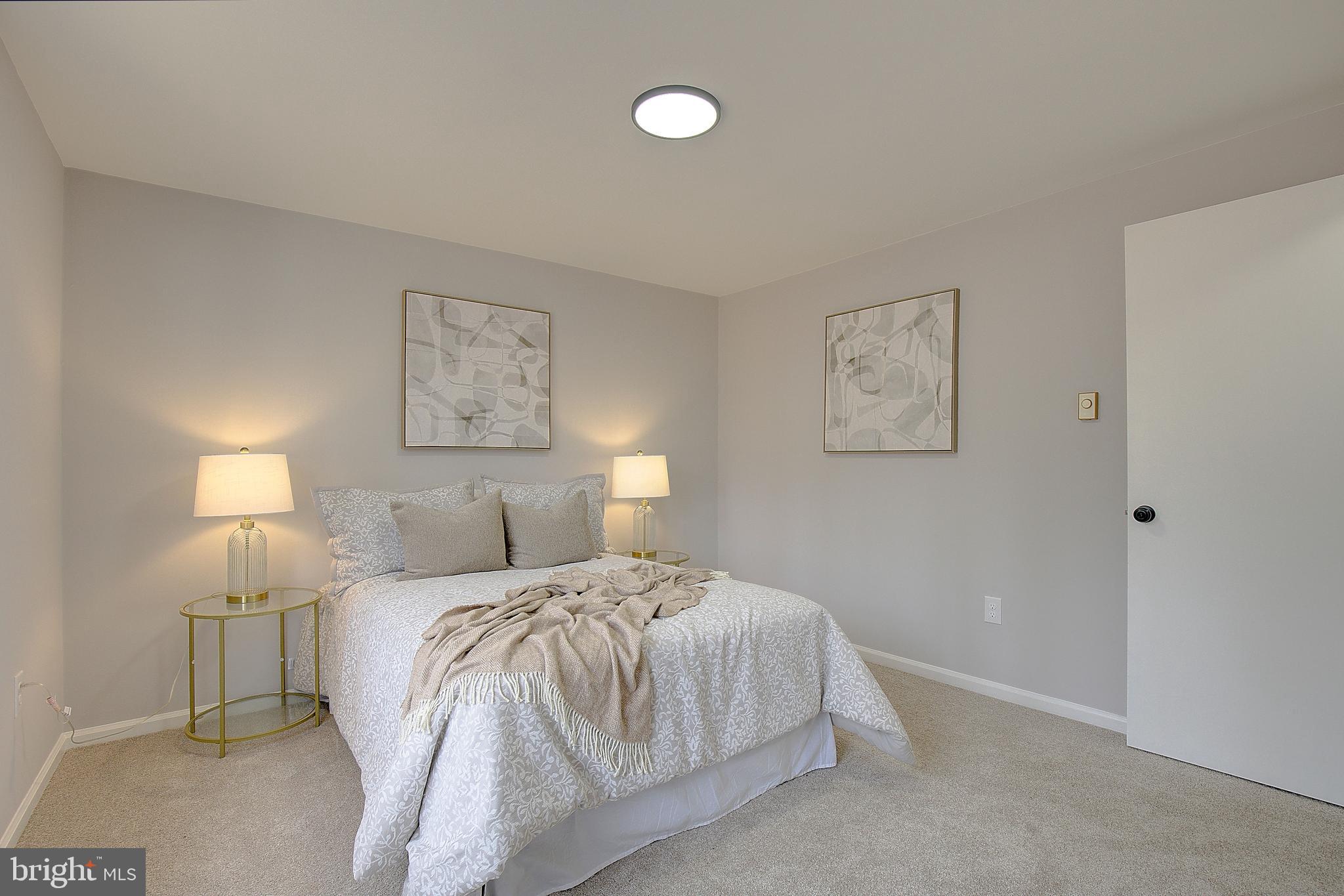 12070 Rousby Hall Road Lusby, MD 20657 - Photo 27 of 36 a bedroom with a bed and a lamp