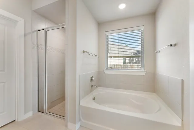 a white bath tub sitting in a bathroom next to a window