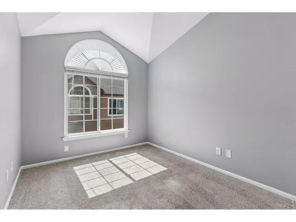 an empty room with windows and wooden floor