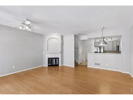 a view of empty room with wooden floor and fireplace