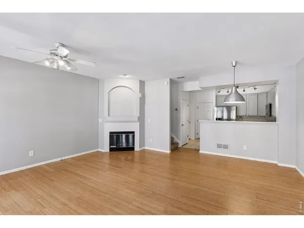 a view of empty room with wooden floor and fireplace