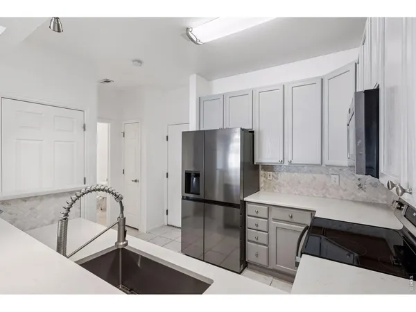 a kitchen with a refrigerator and a sink