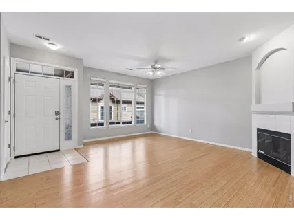 a view of an empty room with window and wooden floor