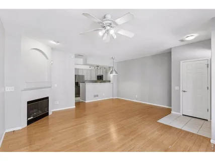 a view of empty room with kitchen and fireplace