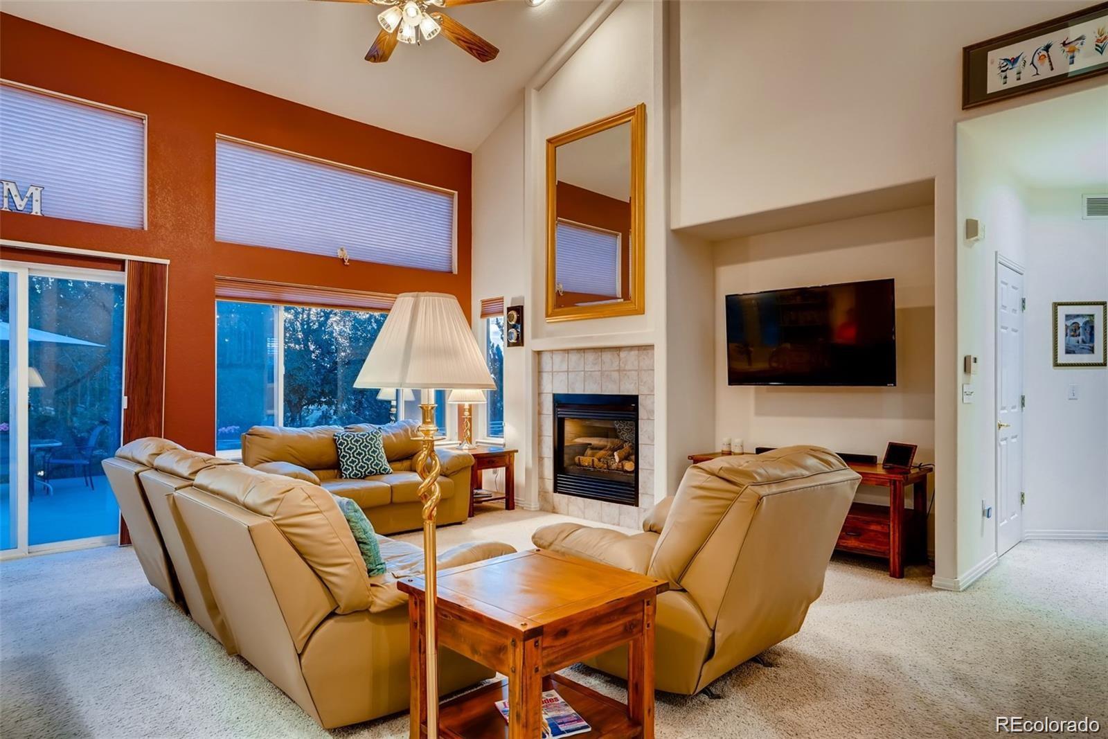 935 Green Gables Circle Bennett, CO 80102 - Photo 13 of 34 a living room with furniture a flat screen tv and a fireplace