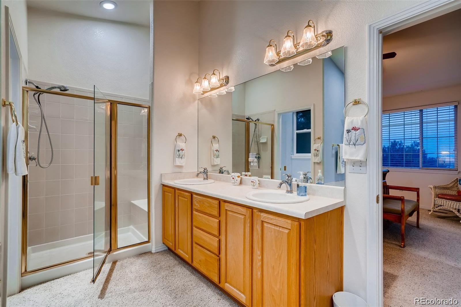 935 Green Gables Circle Bennett, CO 80102 - Photo 23 of 34 a bathroom with a sink double vanity granite tub shower and mirror