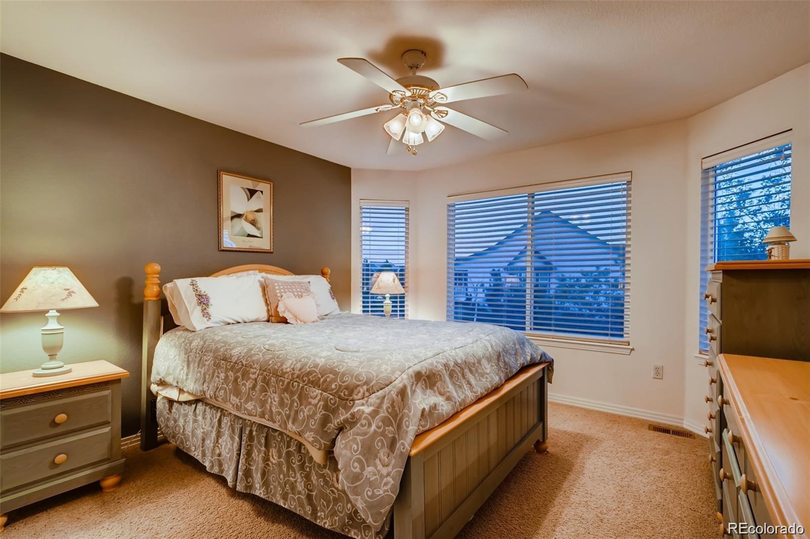 935 Green Gables Circle Bennett, CO 80102 - Photo 26 of 34 a bed room with a bed and a chandelier