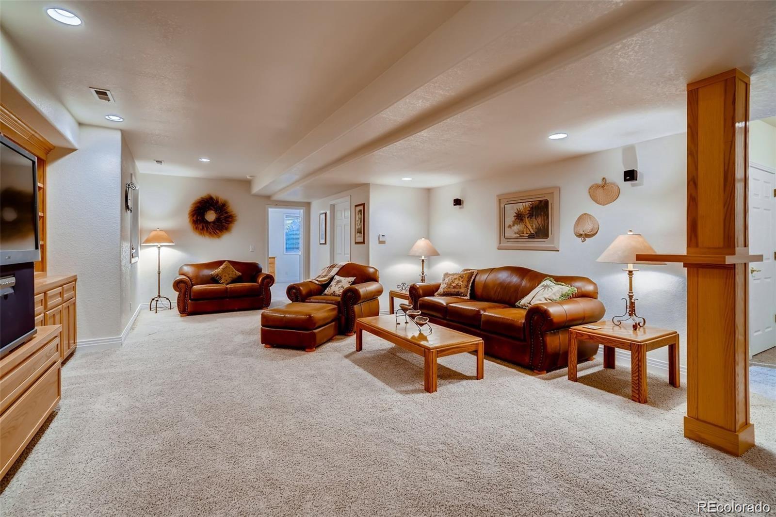 935 Green Gables Circle Bennett, CO 80102 - Photo 27 of 34 a living room with furniture and a flat screen tv