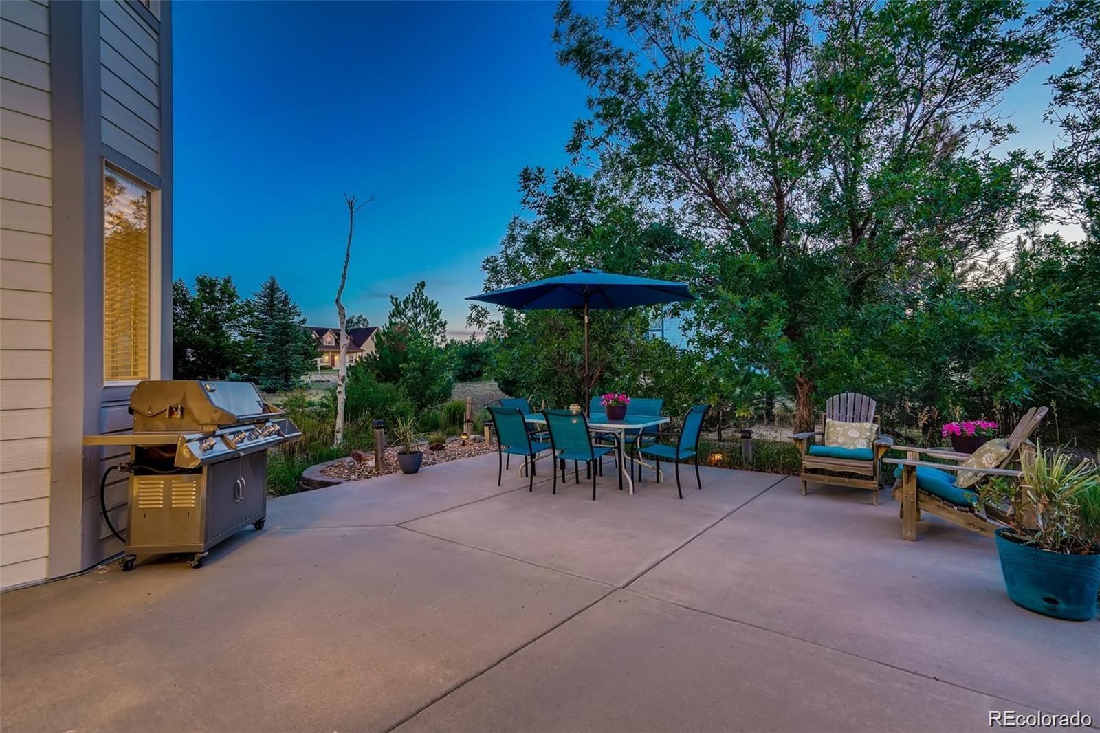 935 Green Gables Circle Bennett, CO 80102 - Photo 31 of 34 a view of chair and tables in the back yard of the house